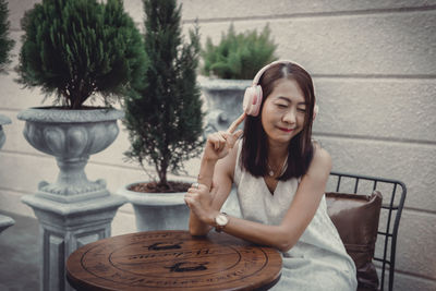 Portrait of smiling young woman sitting on table