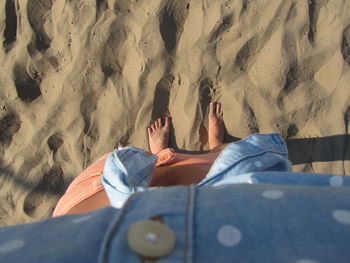 Low section of man lying on sand