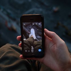 Cropped image of man photographing using mobile phone