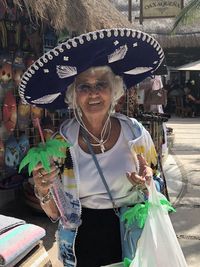 Portrait of smiling woman wearing hat while standing outdoors