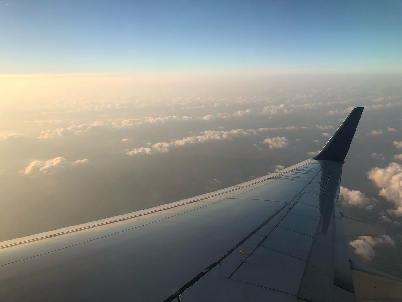 AERIAL VIEW OF AIRPLANE FLYING OVER CLOUDS