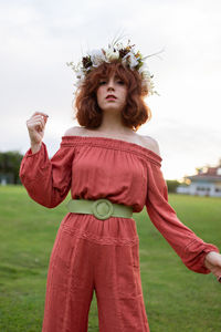Happy girl standing on field against sky