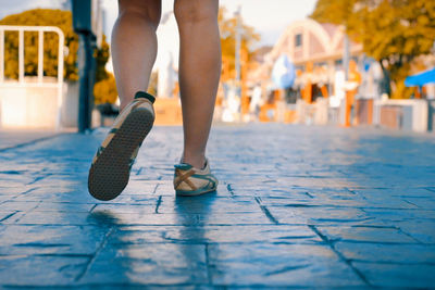 Low section of woman walking in city