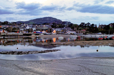 Scenic view of river by town against sky