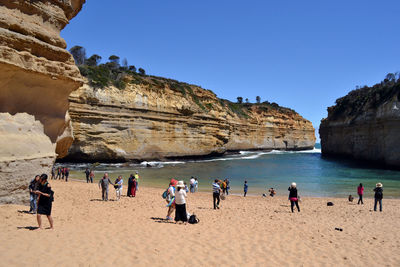 People at beach against clear sky