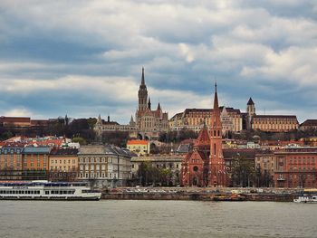 River in city against cloudy sky