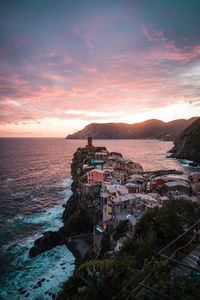 Scenic view of sea by town against sky during sunset