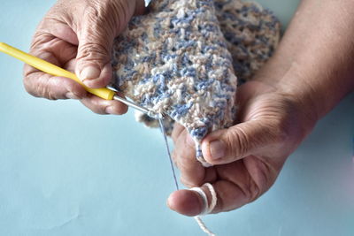 Cropped hands of person knitting wool