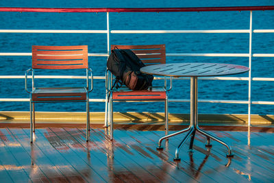 Black photo backpack on a chair on a ship deck