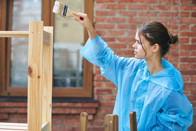 Side view of young man holding mobile phone