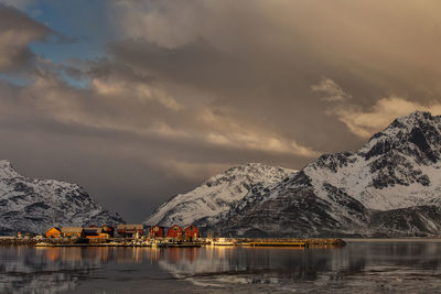 Scenic view of lake by snowcapped mountains against sky