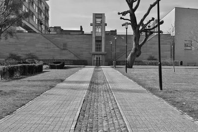 Footpath by building against sky