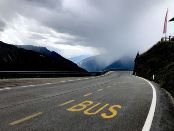 Road leading towards city against sky