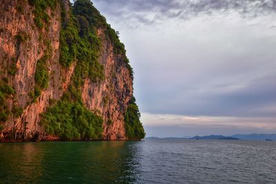 Scenic view of sea by mountains against sky