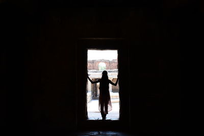 Rear view of silhouette woman standing in entrance