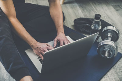 Man resting after working out at home. boy looking online gym exercise video on laptop computer. 