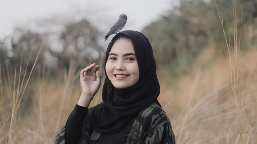 Portrait of smiling young woman standing on field