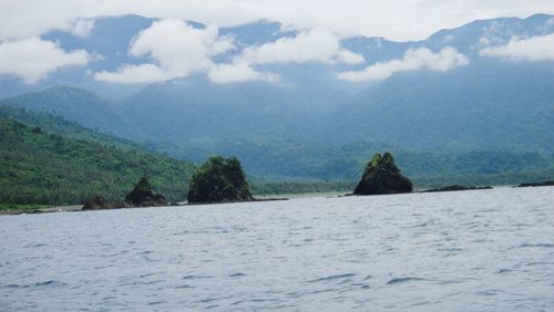 Scenic view of sea and mountains against sky