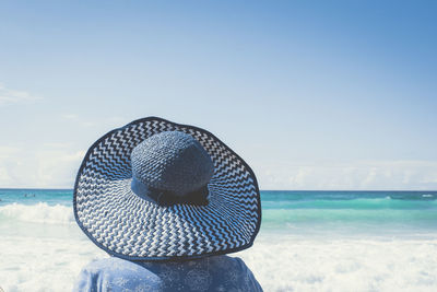 Rear view of woman sitting on the beach