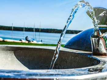 Close-up of drinking fountain against sea