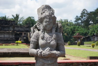 Close-up of buddha statue against sky