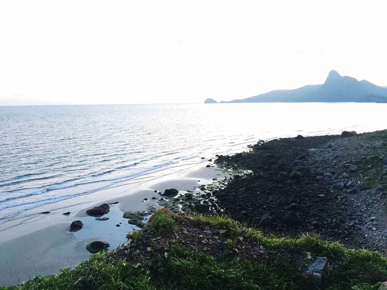 water, sea, tranquil scene, tranquility, scenics, horizon over water, beauty in nature, clear sky, beach, nature, shore, mountain, idyllic, coastline, sky, copy space, remote, high angle view, non-urban scene, outdoors