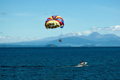 People in sea against sky