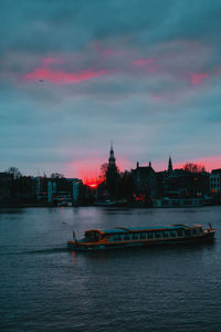 View of buildings at waterfront during sunset