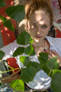 High angle portrait of young woman lying on wooden table