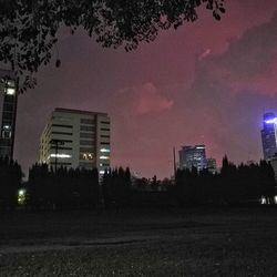 Illuminated buildings against sky at night