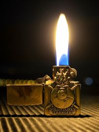 Close-up of burning candle on table