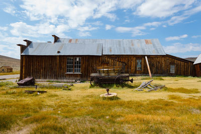 Abandoned house on field against sky