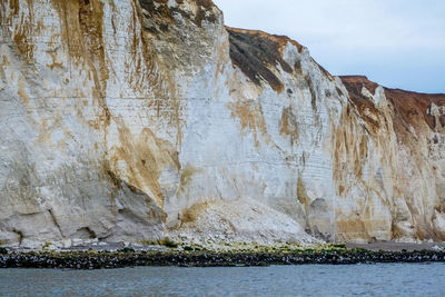 Rock formations by sea against sky