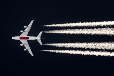Low angle view of airplane flying against sky at night