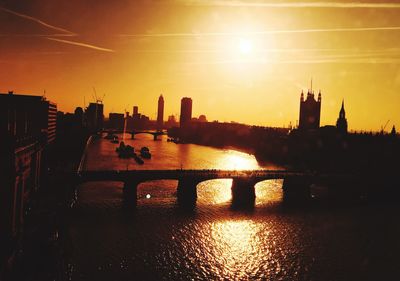 Silhouette buildings against sky during sunset