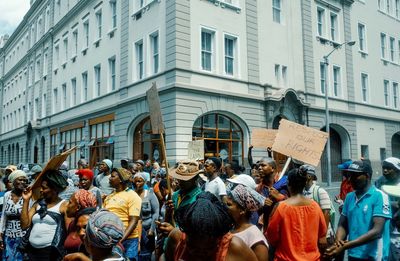 People on street against buildings in city