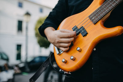 Midsection of man playing guitar