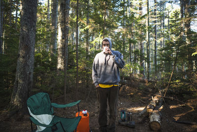 Solo man drinking coffee while camping in coastal maine