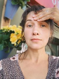 Portrait of young woman holding her head with her hand