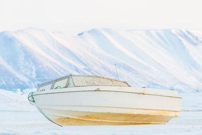 Scenic view of boat and snowcapped mountains against sky