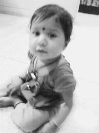 Portrait of baby girl sitting on floor