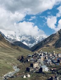 Townscape by mountains against sky