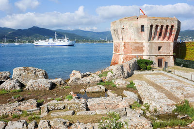 Castle by sea against sky