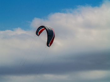 Low angle view of person paragliding against sky