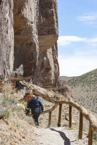 Rear view of woman walking on footpath