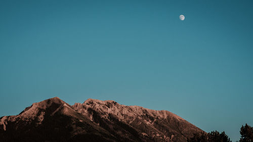 Low angle view of mountain against clear blue sky