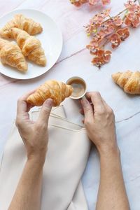 High angle view of hand holding bread on table