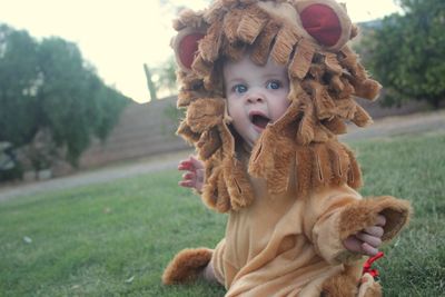 Portrait of cute baby girl wearing costume yawning in park