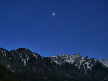 Scenic view of snowcapped mountains against clear blue sky