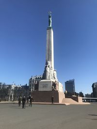 Statue in city against clear sky